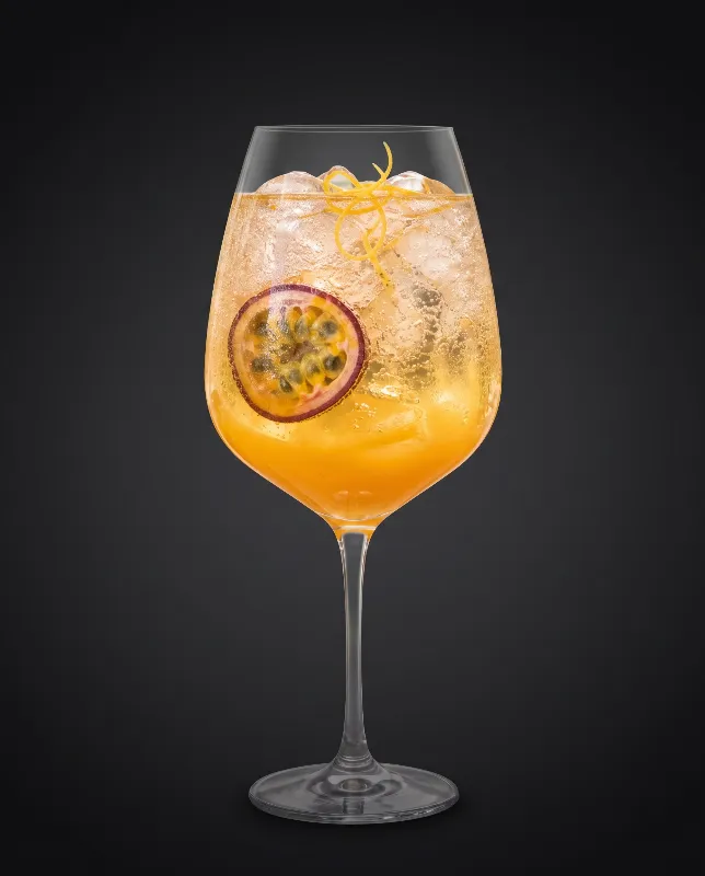 Mango-Maracuja-Spritz im Weinglas mit Maracuja in Gelb und Orange