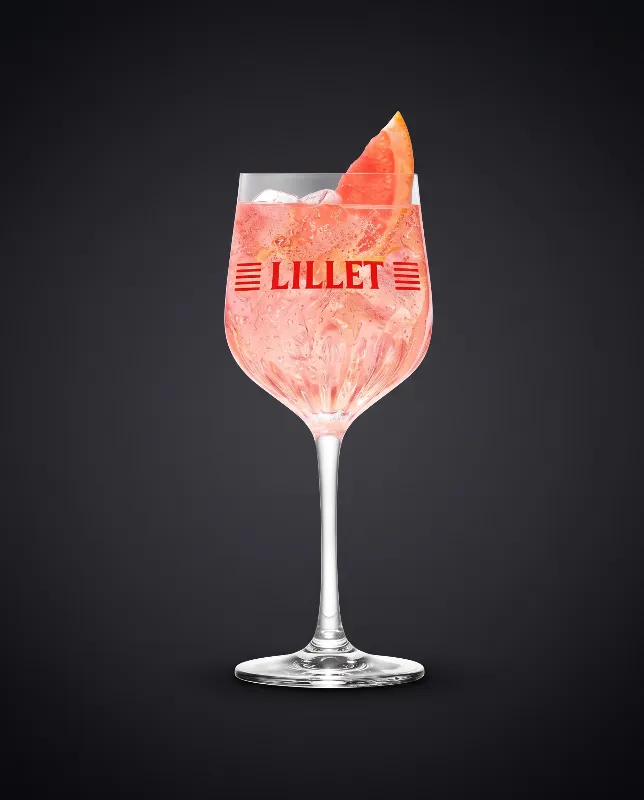Lillet Pink Grapefruit im Weinglas mit rosa Getränk und Grapefruitscheibe