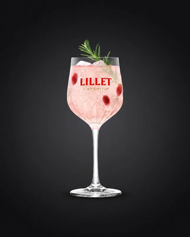Lillet Wild Berry 0 % alkoholfrei im großen Weinglas mit Himbeeren und Rosmarinzweig