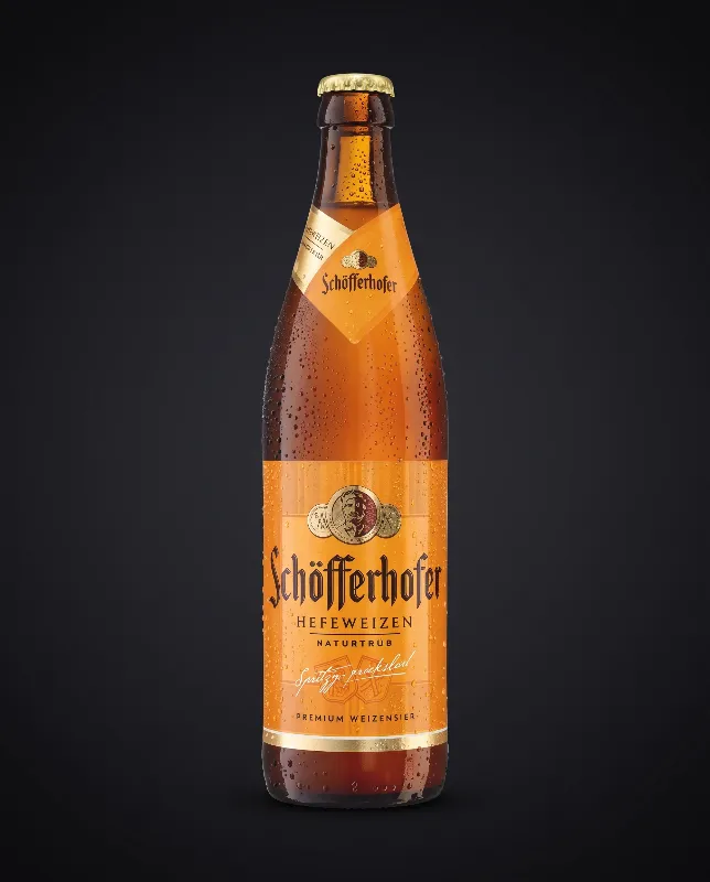 Flasche Schöfferhofer Weizen Hell mit orangem Etikett vor dunklem Hintergrund