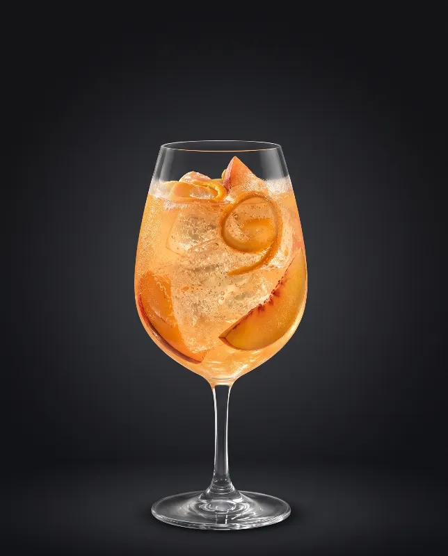 Peach Secco Light im Weinglas mit Orangenspirale und Eis